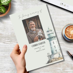 Pode incluir: Um cartão memorial azul claro e branco com uma foto de um homem segurando um gato branco. O cartão tem o texto "Em memória carinhosa de" e "Chris Smith" com as datas de nascimento e morte.