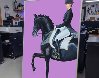 May include: A framed artwork depicts a rider in formal attire on a black horse against a lavender background. The rider wears a black jacket and top hat. The horse is in a dressage pose, with one leg raised.