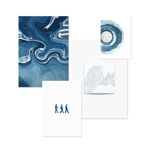 May include: A selection of art prints and a vinyl record. The prints display abstract blue and white patterns, a mountain range illustration, and a minimalist design of three figures walking. The vinyl record is blue and white.