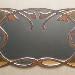 May include: A decorative mirror with a brown and gold frame. The frame has a stylized design with curved lines and a mirrored surface.