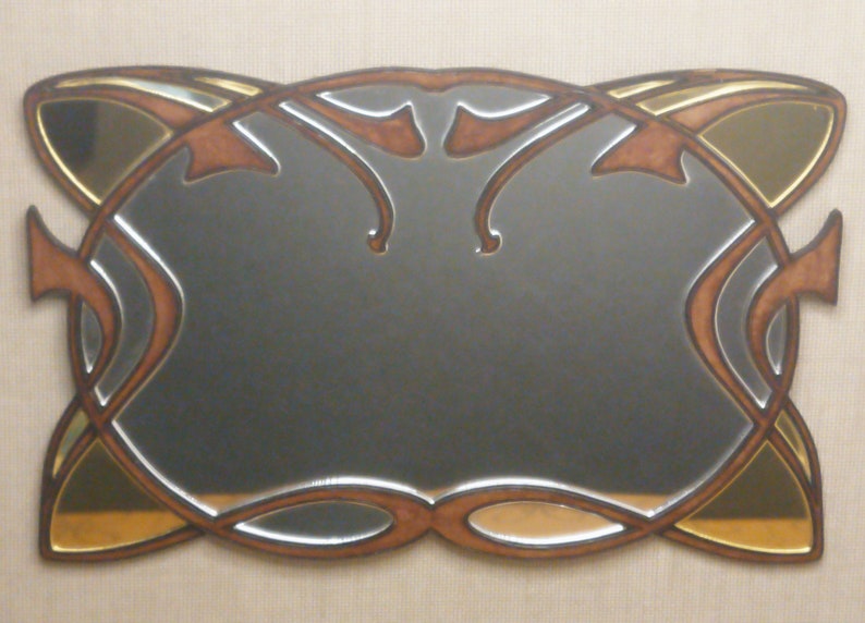 May include: A decorative mirror with a brown and gold frame. The frame has a stylized design with curved lines and a mirrored surface.