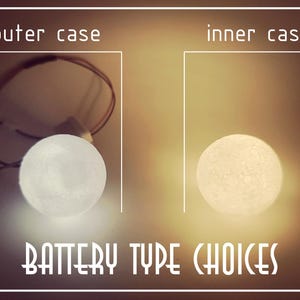 Op de afbeelding: Afbeelding met twee oplichtende bollen, gelabeld "outer case" en "inner case". De tekst "BATTERY TYPE CHOICES" staat eronder. De linkerbol is wit, de rechter is geel.