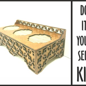 Puede incluir: Un kit de bricolaje de madera para un portavelas de tres niveles con un diseño geométrico. El kit está hecho de madera sin terminar y tiene un color marrón natural. El texto "DO IT YOURSELF KIT" es visible en la imagen.