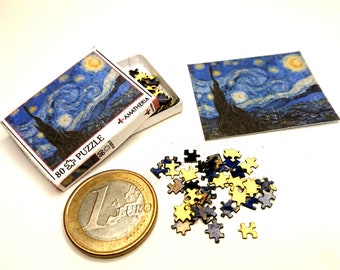 May include: A miniature 80 piece jigsaw puzzle of Vincent van Gogh's Starry Night painting. The puzzle pieces are scattered around a one euro coin. The puzzle box is open and shows the completed image.