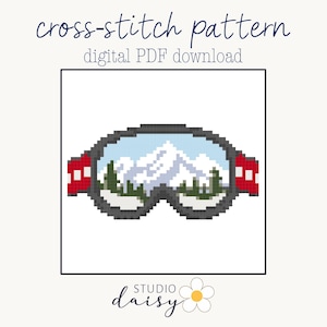 May include: A cross-stitch pattern digital PDF download featuring a pixel art illustration of ski goggles. The goggles have a dark gray frame, red side straps, and a lens reflecting a snowy mountain landscape with white peaks and green pine trees.