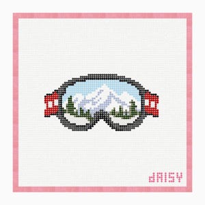 Puede incluir: Un patrón de punto de cruz que muestra unas gafas de esquí con el reflejo de montañas nevadas y pinos verdes en los cristales. Las gafas tienen una montura negra y correas laterales rojas. La palabra daisy está bordada en rosa abajo a la derecha.