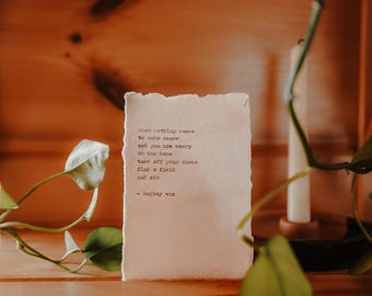 May include: A handwritten poem on a piece of paper with a rustic texture. The poem reads: "When nothing seems to make sense and you are weary to the bone take off your shoes find a field and sit - Hayley Ann"