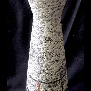 Könnte beinhalten: Eine weiße Keramikvase mit einer strukturierten Oberfläche und schwarzen und goldenen geometrischen Mustern. Die Vase hat eine breite Öffnung und einen schmalen Boden.