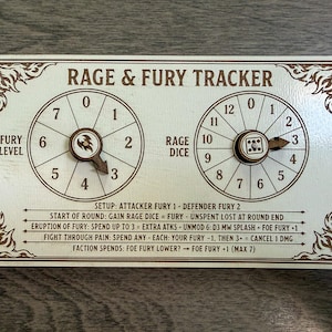 May include: A rectangular wooden game tracker board with a light cream finish and dark brown engraved text and graphics. It features two circular dials labelled FURY LEVEL and RAGE DICE, each with a rotating pointer, and detailed game rules text.