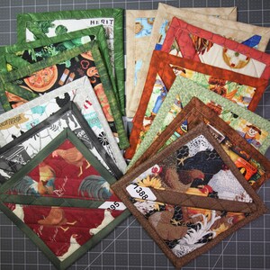 May include: A collection of square fabric pot holders featuring various printed patterns including chickens, sunflowers, and farm-themed motifs. Each piece is finished with a quilted border and some display small white identification tags with numbers.