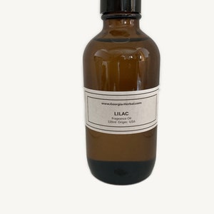 May include: A brown glass bottle with a black cap, labeled "Lilac Fragrance Oil 120ml Origin: USA" and "www.Georgia-Herbal.com".