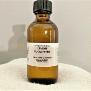 May include: A brown glass bottle with a white label that reads "Georgia-Herbal.com LEMON EUCALYPTUS 100% Pure & Natural Essential Oil Net Wt. 60ml."