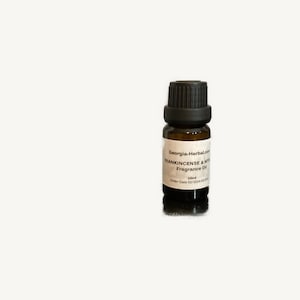 May include: A small brown glass bottle with a black cap, labeled "Georgia-Herbal.com FRANKINCENSE & MYRRH Fragrance Oil 10ml  Order Date 03/2024-00000000"