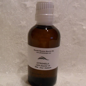 May include: A brown glass bottle with a white label that reads "CITRONELLA 100% Essential Oil 10ml / .33oz / Indonesia".