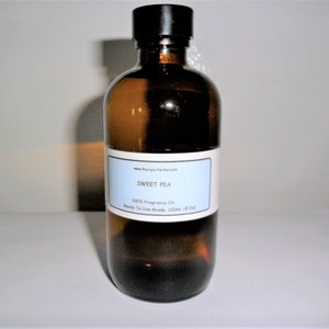 May include: A brown glass bottle with a black cap, containing a clear liquid. The label reads "SWEET PEA 100% Fragrance Oil Ready To Use Grade 120ml (4 fl oz)"