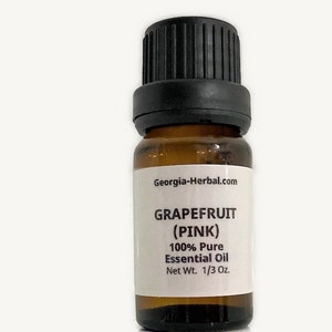 May include: A small amber glass bottle with a black cap, containing pink grapefruit essential oil. The label reads "Georgia-Herbal.com", "GRAPEFRUIT (PINK)", "100% Pure Essential Oil", and "Net Wt. 1/3 Oz."