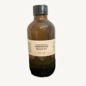 May include: A brown glass bottle of Frankincense essential oil. The label reads "Georgia-Herbal.com FRANKINCENSE 100% Pure & Natural Essential Oil - Gr A". The bottle is sealed with a black cap and contains 120ml of oil.