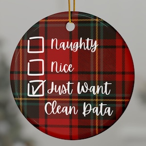 Puede incluir: Un adorno navideño redondo de cerámica con un patrón de cuadros escoceses en rojo, verde y amarillo. El texto dice Naughty, Nice y Just Want Clean Data, con una casilla marcada junto a la última opción. Un cordón dorado cuelga de la parte superior.