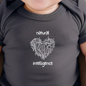 Puede incluir: Un bebé con un body gris oscuro con un diseño de corazón blanco y el texto "inteligencia natural".