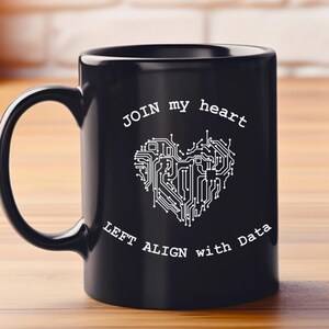 Könnte beinhalten: Zwei schwarze Kaffeetassen mit einem weißen Design. Das Design zeigt eine Leiterplatte in Herzform mit dem Text "JOIN my heart LEFT ALIGN with Data".