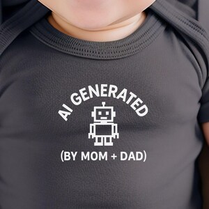 May include: Dark grey baby bodysuit featuring the text "AI GENERATED" and a robot graphic. Below the text is "(BY MOM + DAD)" in white. The bodysuit is on a baby.