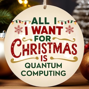 May include: A round Christmas ornament with the text "ALL I WANT FOR CHRISTMAS IS QUANTUM COMPUTING". The ornament is cream-colored with red and green text and a string for hanging. Christmas decor is in the background.
