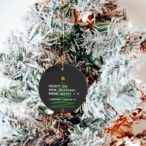 A Christmas tree decorated with ornaments, including a round ornament with text that reads "SELECT joy FROM christmas WHERE spirit = 0 TIMESTAMP: 2020-12-23".
