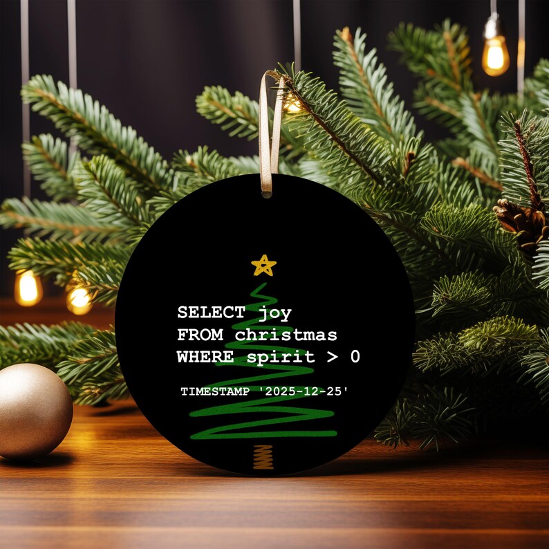 A black circular ornament with a Christmas tree design and text, placed on a wooden surface with Christmas lights in the background.