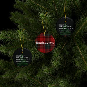 a Christmas tree adorned with three ornaments hanging from its branches. The ornaments are black and red plaid, and they display the text "SELECT joy FROM christmas WHEN spirit > 0" and "Christmas 2015" respectively.
