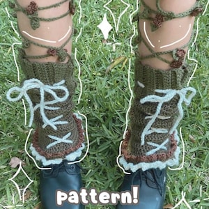 Puede incluir: Calentadores de piernas de ganchillo en verde oliva, marrón y azul claro, con un diseño de cordones y detalles de vid floral. El texto "pattern!" es visible en la imagen. Los calentadores de piernas se usan con zapatos negros.