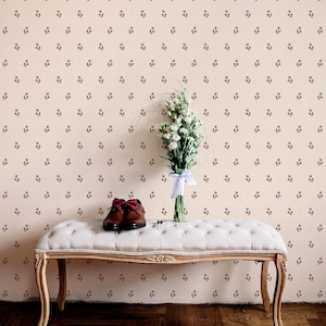 Peut inclure: Un banc blanc capitonné avec des pieds en bois sculpté supporte une paire de chaussures en cuir marron avec des lacets bordeaux et un bouquet de fleurs blanches noué avec un ruban blanc. Le fond est un mur crème avec un motif floral.