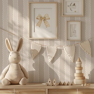 May include: A nursery scene with a plush bunny, framed artwork, and wooden toys. The artwork includes a bow, a whale, and a bunny. A garland of fabric pennants hangs across the wall. The color palette is soft beige and cream.