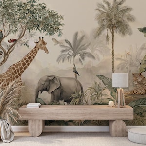 Op de afbeelding: Een muurschildering met een junglescène met een giraffe, een olifant en een luipaard. Het kunstwerk toont palmbomen, weelderig gebladerte en vogels. Een houten bank en een lamp staan op de voorgrond, met een neutraal kleurenpalet. Geschikt voor interieurdecoratie.
