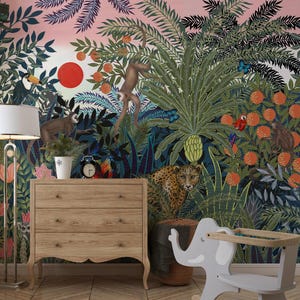 Pode incluir: Um vibrante papel de parede com tema de selva com macacos, um leopardo e um tucano em meio a uma vegetação exuberante e laranjeiras. Uma cômoda de madeira, uma luminária de chão e uma cadeira infantil em forma de elefante estão em primeiro plano.