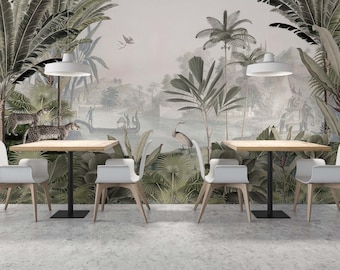 May include: A dining room with a tropical mural wallpaper featuring palm trees, a lake, and birds. Two square wooden tables with black metal legs are set with white chairs.