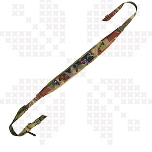 May include: A patterned rifle sling with adjustable straps. The sling features a mix of colors including green, brown, and blue. The text "HYDRA", "WTF", and "FRANKENSTEIN" are visible.