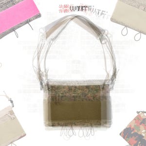 May include: A crossbody bag with a camouflage pattern and a solid olive green front pocket. The bag has a long strap and is surrounded by other bags in pink, beige, and camouflage patterns. The bags have drawstrings and are likely for carrying small items.