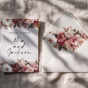May include: A wedding invitation suite with a floral design in white, pink, and burgundy. The invitation card and envelope are on a neutral background. The card reads "Save the Date 15 October 2026" and "Mia and Jackson".