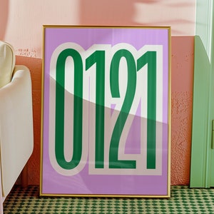 May include: A framed print with a light purple background and the number 0121 in bold green letters.