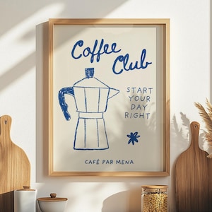 Puede incluir: Un estampado enmarcado con un fondo beige claro presenta texto azul y una ilustración azul de una cafetera italiana. El texto dice "Coffee Club" y "Start Your Day Right". El marco es de color marrón claro.