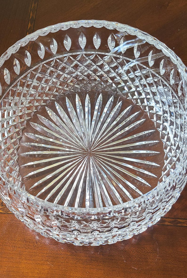Puede incluir: Un cuenco de cristal tallado transparente con un patr&oacute;n detallado. El cuenco presenta un dise&ntilde;o tallado en forma de diamante en los lados y un patr&oacute;n de rayos de sol en la base. El borde tiene cortes ovalados. Ideal para servir.