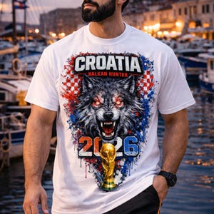 Puede incluir: Camiseta blanca con un gr&aacute;fico de lobo, el texto "CROATIA BALKAN HUNTER 2026" y un trofeo dorado. El dise&ntilde;o incorpora elementos rojos, blancos y azules. La camiseta la lleva una persona.