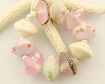 Juego de cuentas de vidrio soplado con platillo mate grabado en plata, rosa y crema.