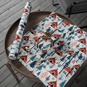 May include: White wrapping paper with a repeating pattern of red and orange tents, green pine trees, and snowflakes. The paper is rolled up and a smaller piece is wrapped around a gift box.