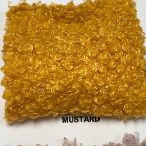 A square swatch of mustard yellow curly teddy fleece fabric with the word MUSTARD printed below.
