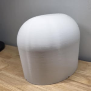May include: A white, rounded, cylindrical object with a textured surface. The object is likely a decorative item or a component of a larger product. The design is simple and modern, with a focus on form.