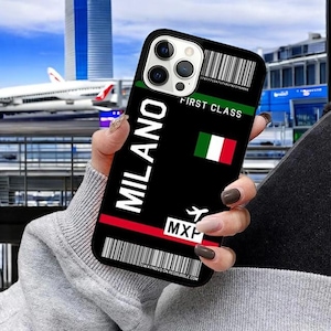 May include: Black phone case with a boarding pass design. The case features the text "MILANO" and "FIRST CLASS" with an Italian flag and the airport code "MXP".