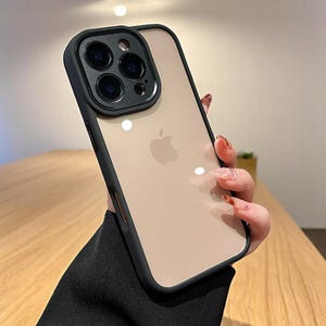 Könnte beinhalten: Eine schwarze Handyhülle mit durchsichtiger Rückseite und einem erhöhten Kameraschutz. Die Hülle ist für ein iPhone mit einem Dreifach-Kamerasystem konzipiert.