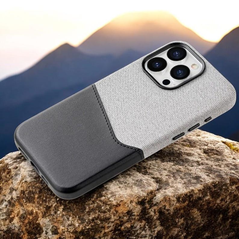 May include: A gray and black phone case with a textured fabric design. The case has a raised camera bump and a cutout for the phone's buttons.