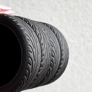 May include: Close-up of three black tire-tread patterned silicone rings stacked on top of each other.